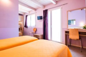里米尼玛丽芙蓉酒店 的一间卧室设有两张床、一张桌子和一个窗口。