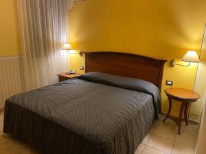 科马基奥Locanda La Comacina的一间卧室配有一张床、一张桌子和两盏灯。