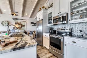 多芬岛Sassy Seagull的厨房配有白色橱柜和不锈钢用具