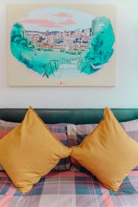 谢菲尔德太空萨韦尔公寓的一张带两个黄色枕头和绘画的床
