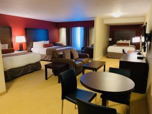 因弗米尔因弗米尔卡纳塔酒店的酒店客房带两张床和一张桌子以及椅子。