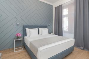布拉格Eight Secrets Boutique Residence的卧室配有白色的床和蓝色的墙壁