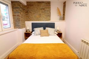 韦加港Apartamentos Puerto Norte - Apto 1的一间卧室配有一张带黄色毯子的大床