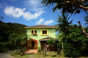 龙乡町Villa Yurimun的一座绿屋,有红门和棕榈树