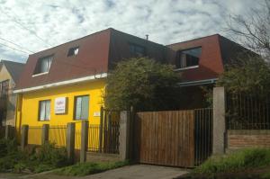 孔斯蒂图西翁Hostal Casona del Cerro的黄色房屋,屋顶为棕色,围栏