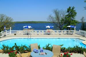 霍利Silver Birches Resort的一个带椅子和桌子的游泳池以及水