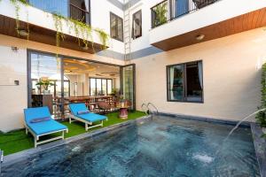 会安Seaweed Luxury Villa & Spa的一座带两把蓝色椅子的别墅内的游泳池