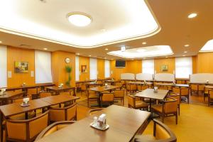 名古屋名古屋荣鲁泰因酒店的一间空餐厅,配有木桌和椅子
