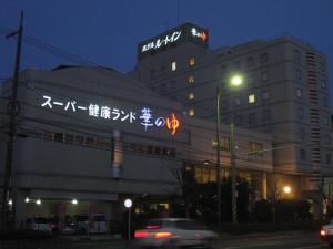 福山福山温泉格兰蒂亚路线度假酒店的一座建筑,晚上在建筑的一侧写字
