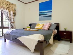 Kampong Alor GajahA famosa Resort Villa with private pool by BeeStay 10 pax的一间卧室配有一张床,上面有托盘