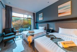 邦劳Begonia Resort 薄荷岛海棠度假酒店的酒店客房带两张床、椅子和窗户