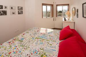 普拉亚达巴拉Barra Beach House - Praia da Barra的一间卧室配有一张床和一张红色的沙发