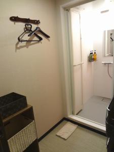 和歌山Guesthouse kukuru的淋浴间,墙上挂着门和枪