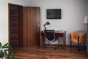 克卢日-纳波卡Cabrio Apart Hotel的客房设有书桌、椅子和电视。