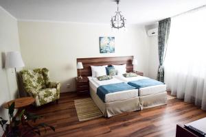 克卢日-纳波卡Cabrio Apart Hotel的一间卧室配有一张床、一把椅子和一个吊灯。
