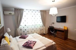 克卢日-纳波卡Cabrio Apart Hotel的一间卧室设有两张床、一张桌子和一个窗口。