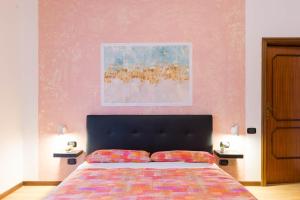 圣焦万尼泰亚蒂诺B&B Pescara Airport的卧室配有一张床,墙上挂有绘画作品