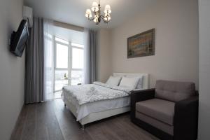 基辅Stylish Panoramic apartments Dnipro Sail riverside的一间卧室配有一张床、一张沙发和一个窗口