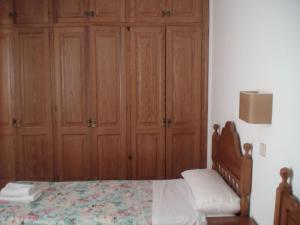 蓬塔格罗萨洛克斯码头公寓的一间卧室配有一张床和木制橱柜