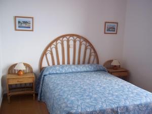 蓬塔格罗萨洛克斯码头公寓的一间卧室配有一张带蓝色棉被的床和两张桌子