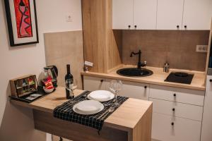波德戈里察Apartments Doclea的厨房配有带2个玻璃杯和水槽的台面
