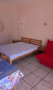 蒂瓦特Apartments Olga的一间卧室配有两张床和红色椅子