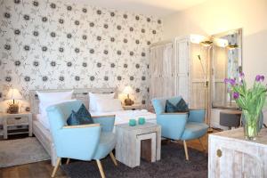 奥斯赛拜-屈隆斯博恩Appartmenthaus Monika的一间卧室配有一张床和两张蓝色椅子