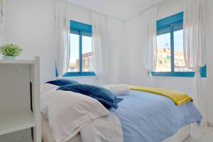 科尔多瓦CONFORT CORDOBA CENTRO II的白色卧室配有蓝色和白色枕头的床