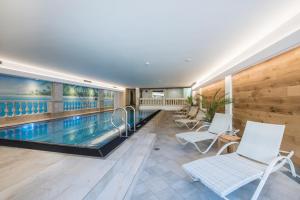 圣安东阿尔贝格科提斯酒店的一座带白色椅子的游泳池