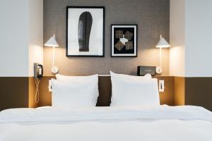 乌得勒支The Hunfeld的一间卧室配有一张带白色床单和两盏灯的床。