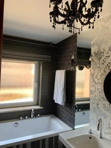 Malnia林德酒店的带浴缸、水槽和窗户的浴室