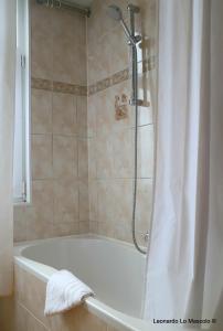列日Hôtel de l'Univers Liège的浴室内设有带浴帘的白色浴缸