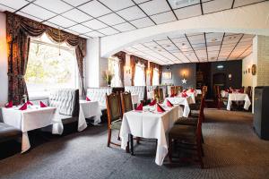 特伦特河畔斯托克博赫阿姆酒店的用餐室配有桌椅和白色桌布