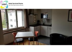 伯尔尼HSH Breitenrain - Serviced Apartment - Bern City by HSH Hotel Serviced Home的厨房配有桌子和两把椅子、一张桌子和一张桌子。