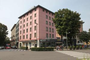 贝加莫皮埃蒙特贝斯特韦斯特酒店的街道边的粉红色建筑