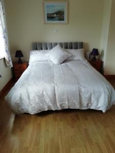 巴利纳Lisduvogue House的卧室内的一张带白色棉被的床