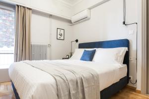 雅典Deluxe & Stylish 2BD Apartment in Pangrati by UPSTREET的一间卧室配有一张大床和蓝色床头板