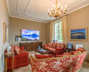 梅纳焦The Lake Como Villa的客厅配有红色家具和吊灯。