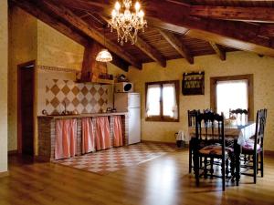 贝拉德蒙凯奥CASA RURAL VILLA DE VERA的厨房以及带桌子和吊灯的用餐室。