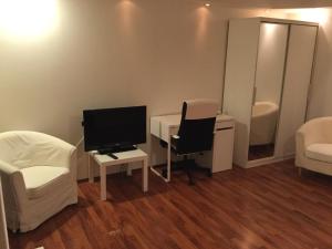布加勒斯特Garsoniera zona baneasa的客房设有书桌、电视和椅子。