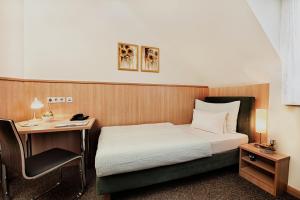 维也纳卡斯帕膳食公寓酒店的配有一张床和一张书桌的酒店客房