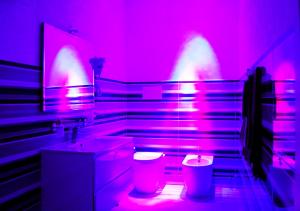 福贾B&b Vittorio Emanuele II的浴室设有粉红色和紫色的灯和卫生间