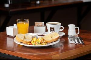 伊基托斯Central Bed & Breakfast的早餐盘包括鸡蛋、烤面包和一杯咖啡