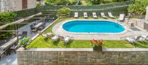 梅纳焦The Lake Como Villa的庭院内的游泳池,配有椅子和桌子
