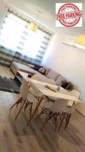 德布勒森Hatvan Corner Apartments的客厅配有白色的桌子和椅子