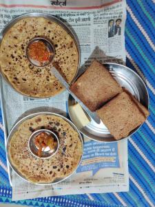 布什格尔Varah Square Guest House的报纸,有三碗汤和三明治