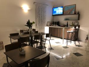 艾米利亚地区格拉纳罗洛阿勒斯库勒乡间别墅公寓的一间带桌子的餐厅和一间墙上配有电视的酒吧