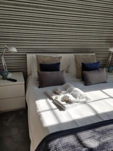 波尔图布拉加斯一室公寓的卧室配有一张白色大床和条纹墙