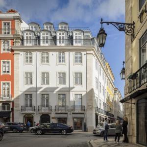 里斯本Lisbon Serviced Apartments - Madalena的街道上一座大型白色建筑,设有阳台