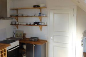 SkudeneshavnCharming flat in cosy farmhouse的厨房配有笔记本电脑,位于柜台和门上